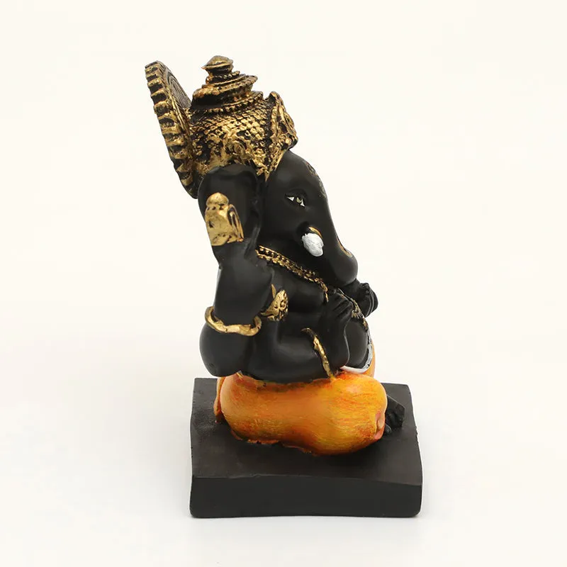 Side view of Ganesh idol in black and orange with gold accents
