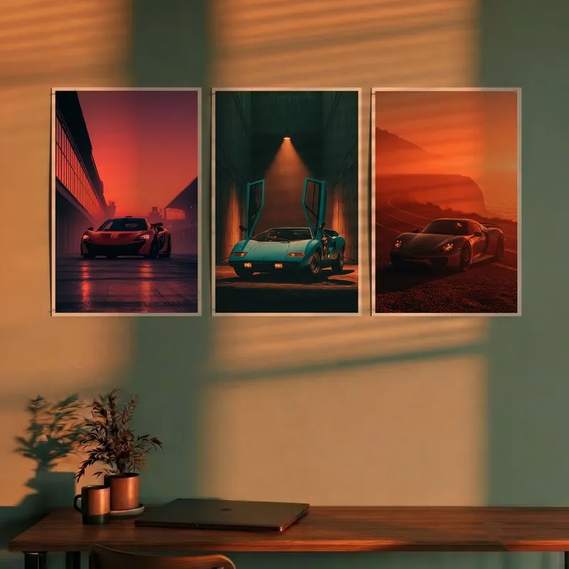Set of three car posters displayed above a desk in warm sunset tones