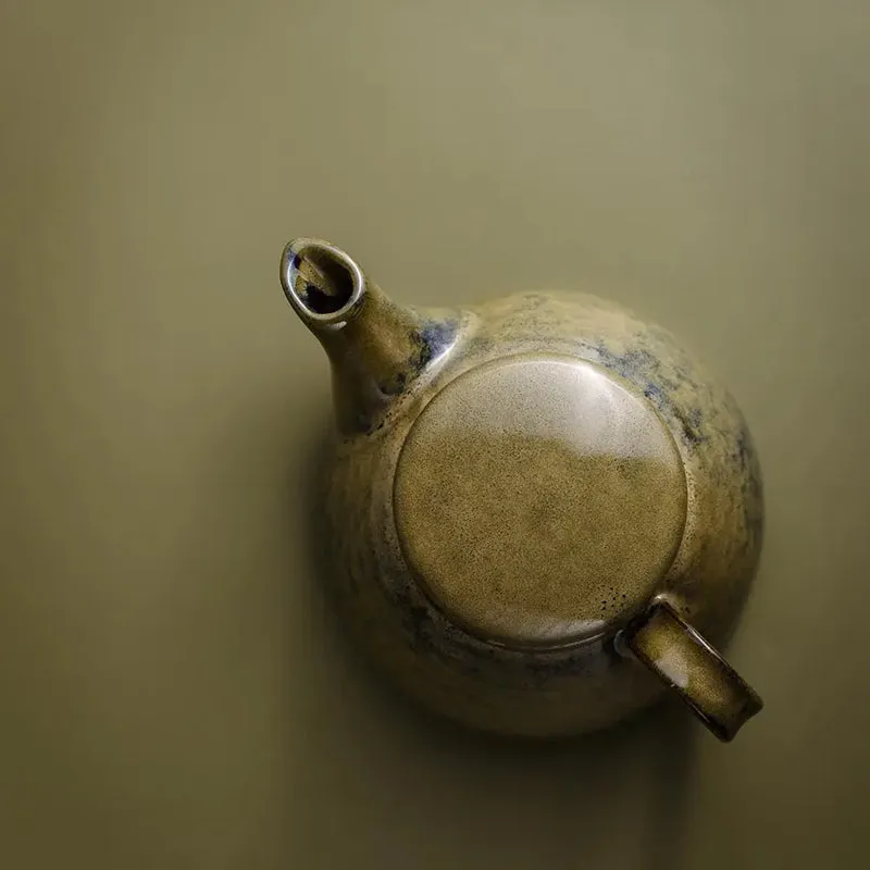 Round green ceramic serving piece with a short spout