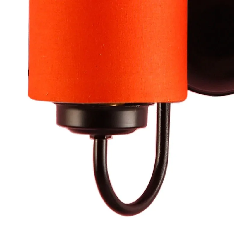 Close-up of orange cotton shade and black curved iron arm
