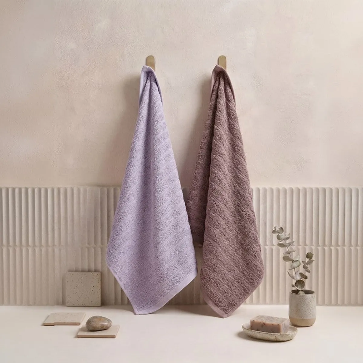 Purple and brown towels hanging in a bathroom setting