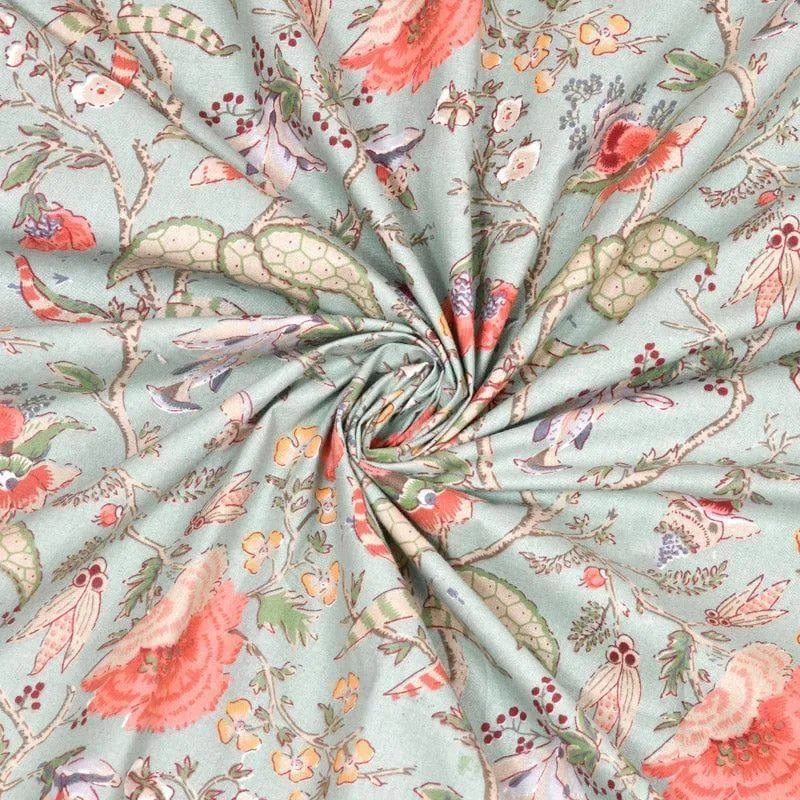 Close-up of pale aqua floral curtain fabric with coral flowers and botanical motifs.