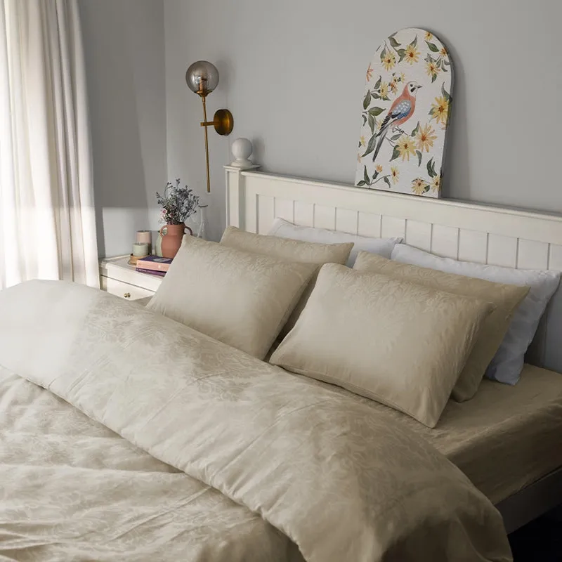 Beige floral bedsheet and pillow covers styled in a bright bedroom