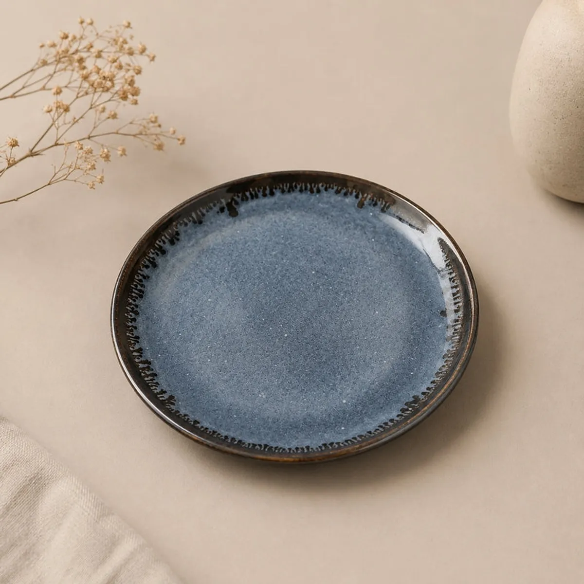 Single deep blue ceramic plate with a dark textured rim