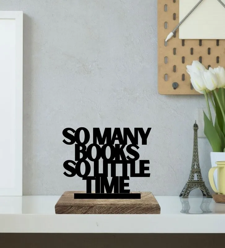 Black typography showpiece on a wooden base displayed on a shelf