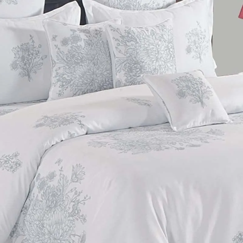 White comforter with soft grey floral print shown on a bed