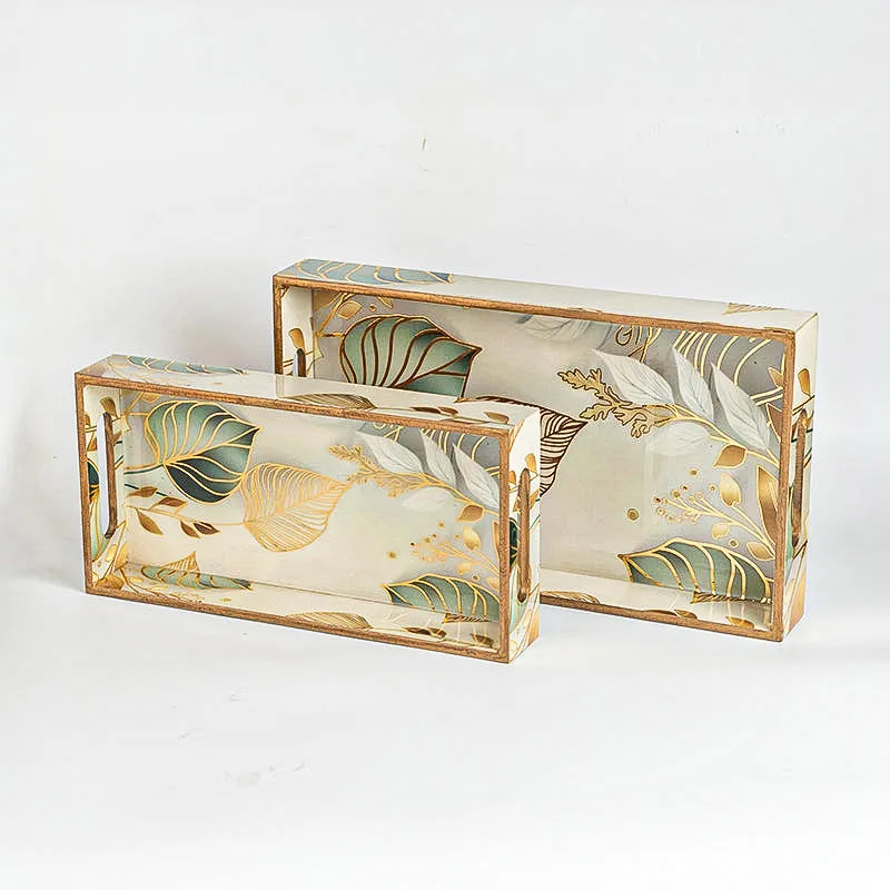 Nested rectangular serving trays with side handles and leaf motif