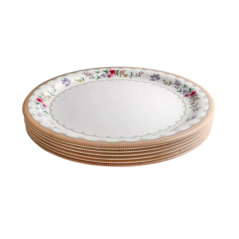 Side view of a white floral dinner plate showing its raised scalloped rim