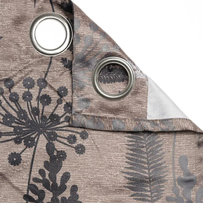 Close-up of curtain fabric showing silver eyelets and botanical print