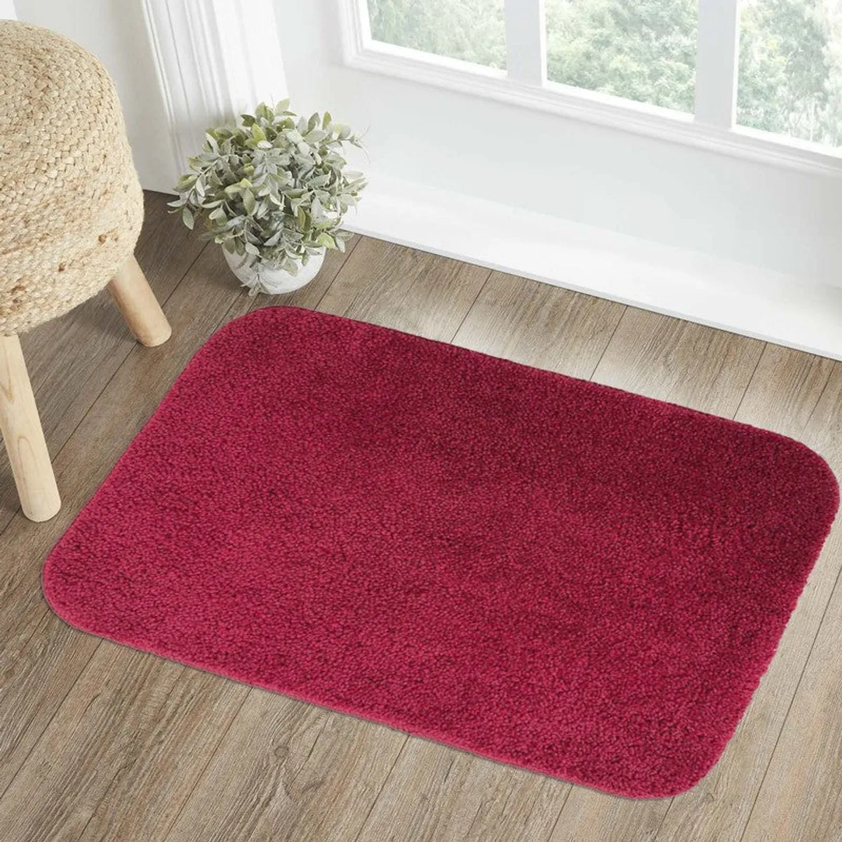 Single maroon bath mat shown on a light wood floor
