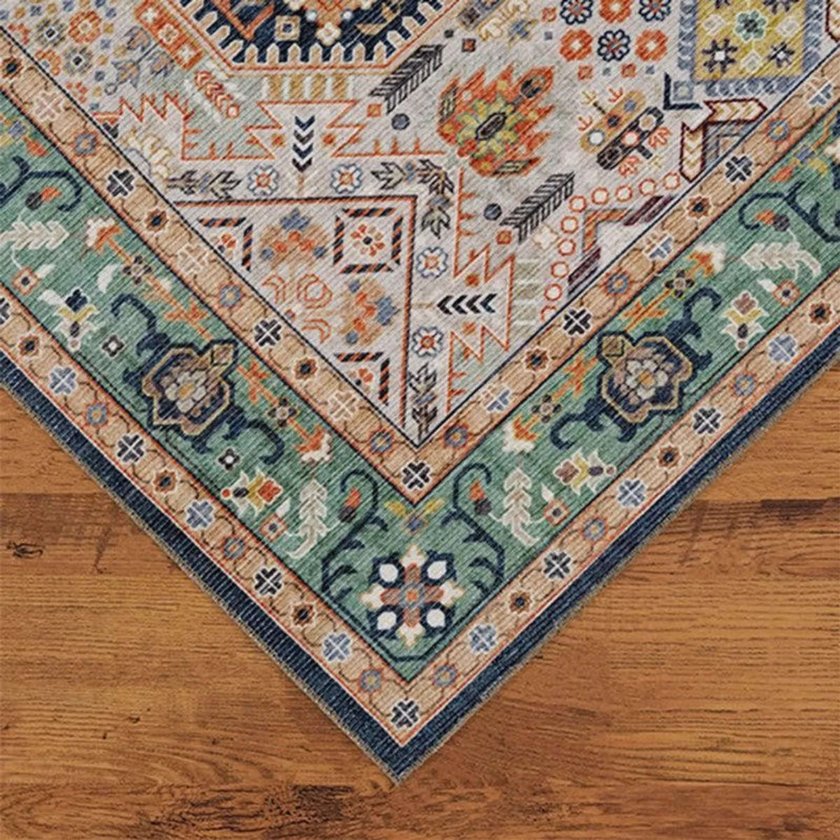 Corner detail of green border and multicolour ethnic pattern on carpet