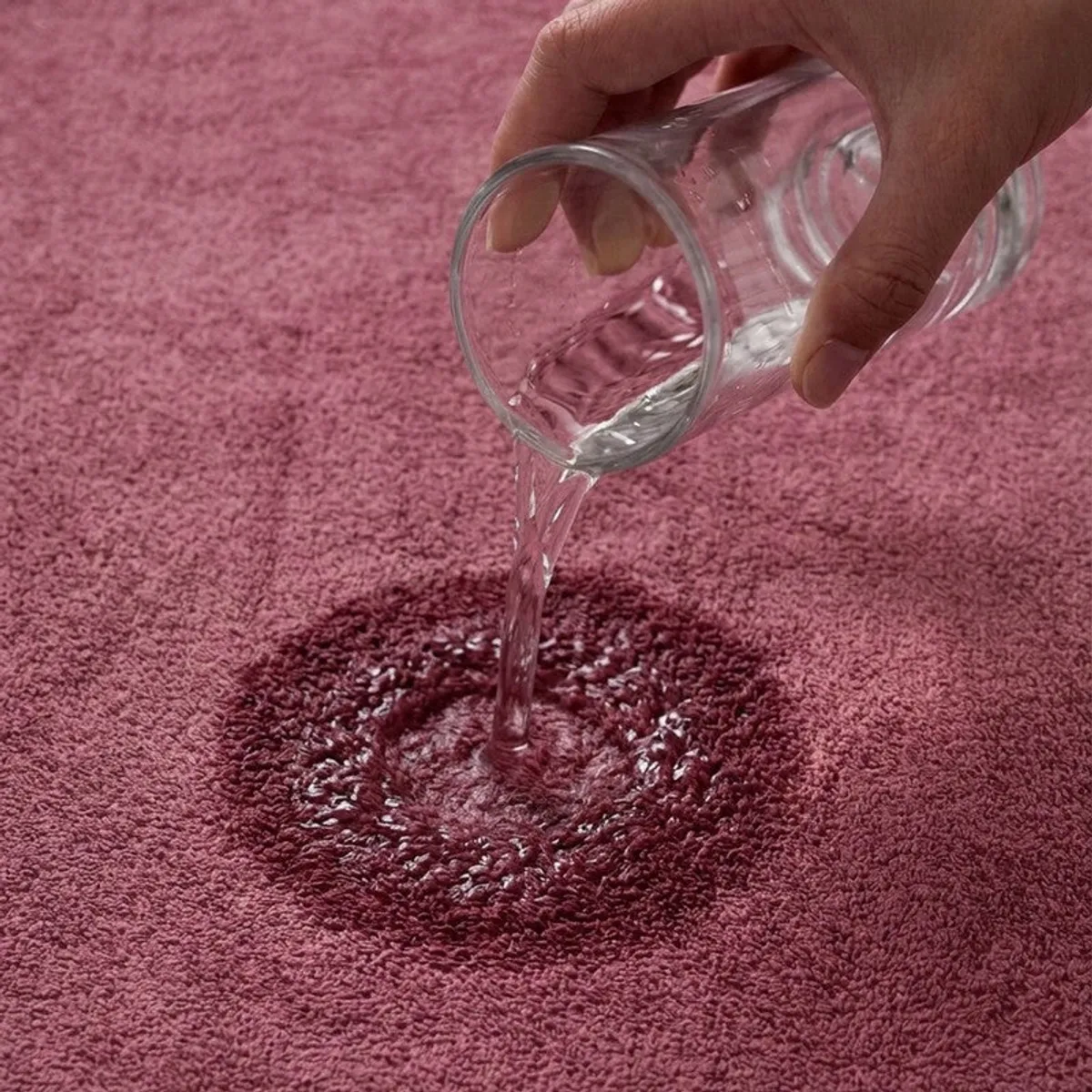 Close-up of water being absorbed by a dusty pink towel
