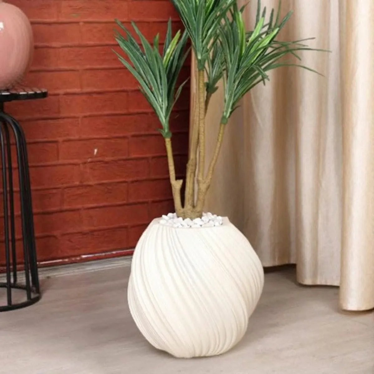 Detailed view of the white planter's rounded ribbed body and plant opening