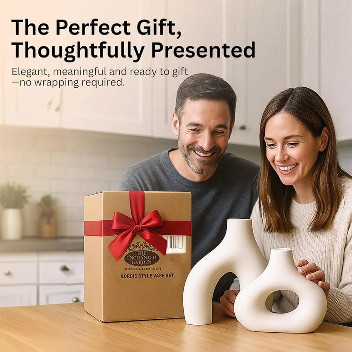 A couple seated at a table beside a boxed set and two white sculptural vases.