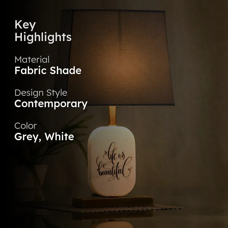 Grey shade table lamp with white marble base shown lit with highlight text overlay