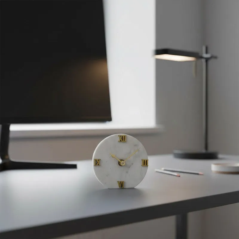 White marble table clock with gold numerals placed on a desk