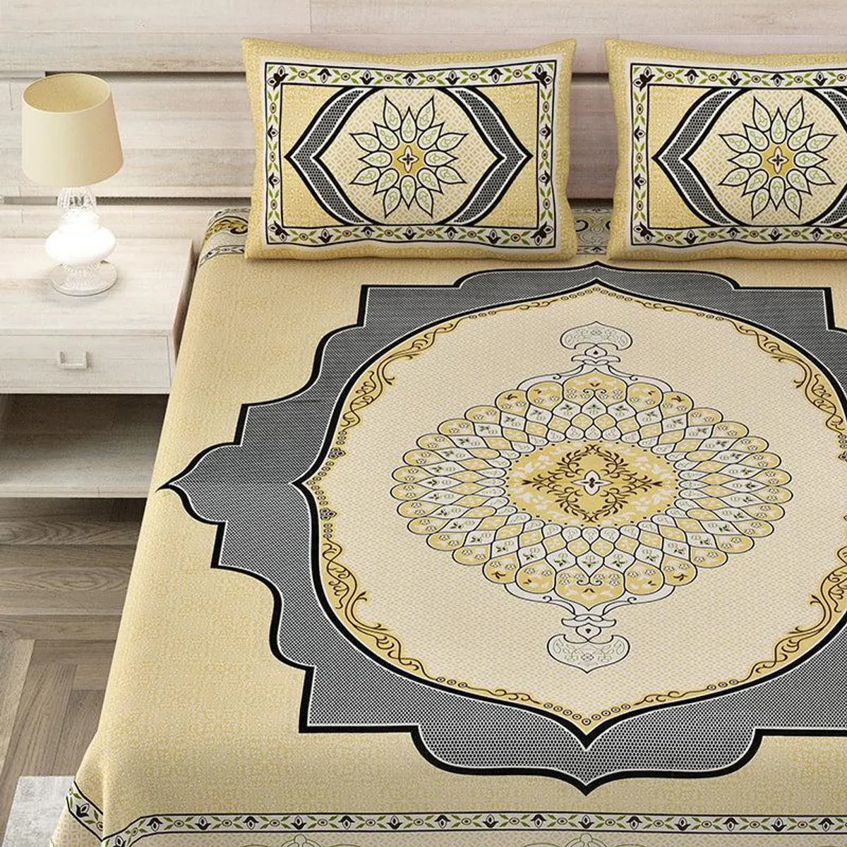 Close view of yellow bedsheet with ornate central medallion and matching pillow covers