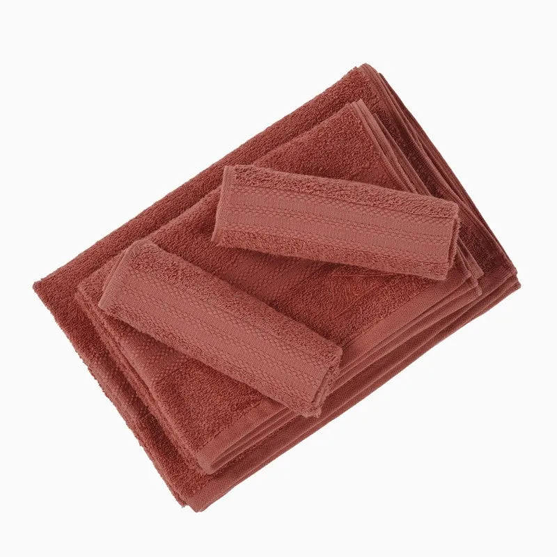 Rust bath and hand towels folded together on a white background