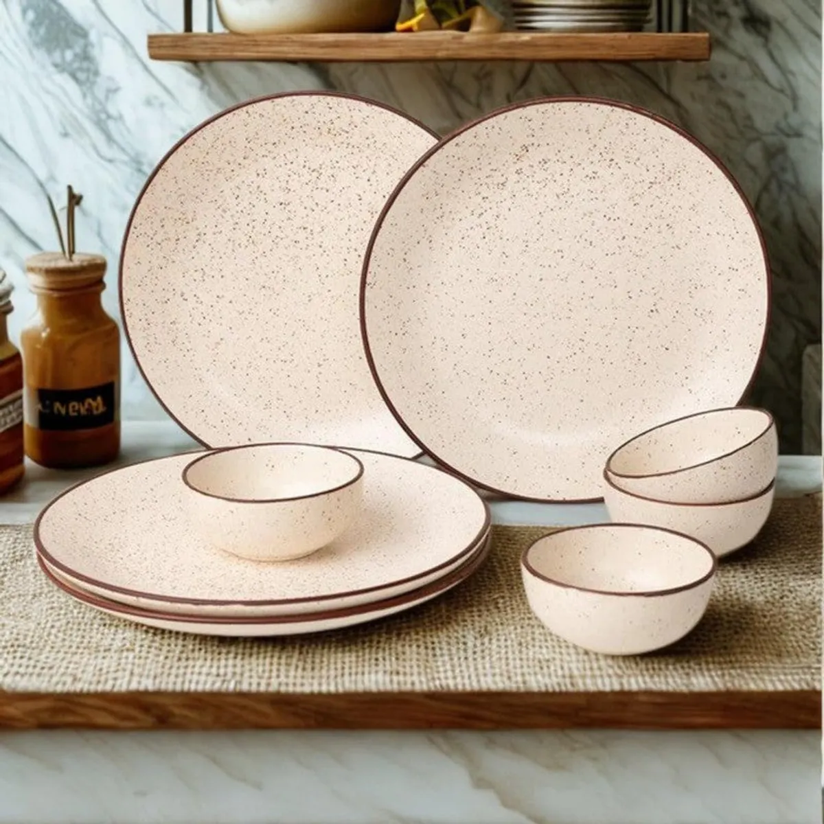 Beige speckled dinnerware with brown rims arranged on a wooden serving board