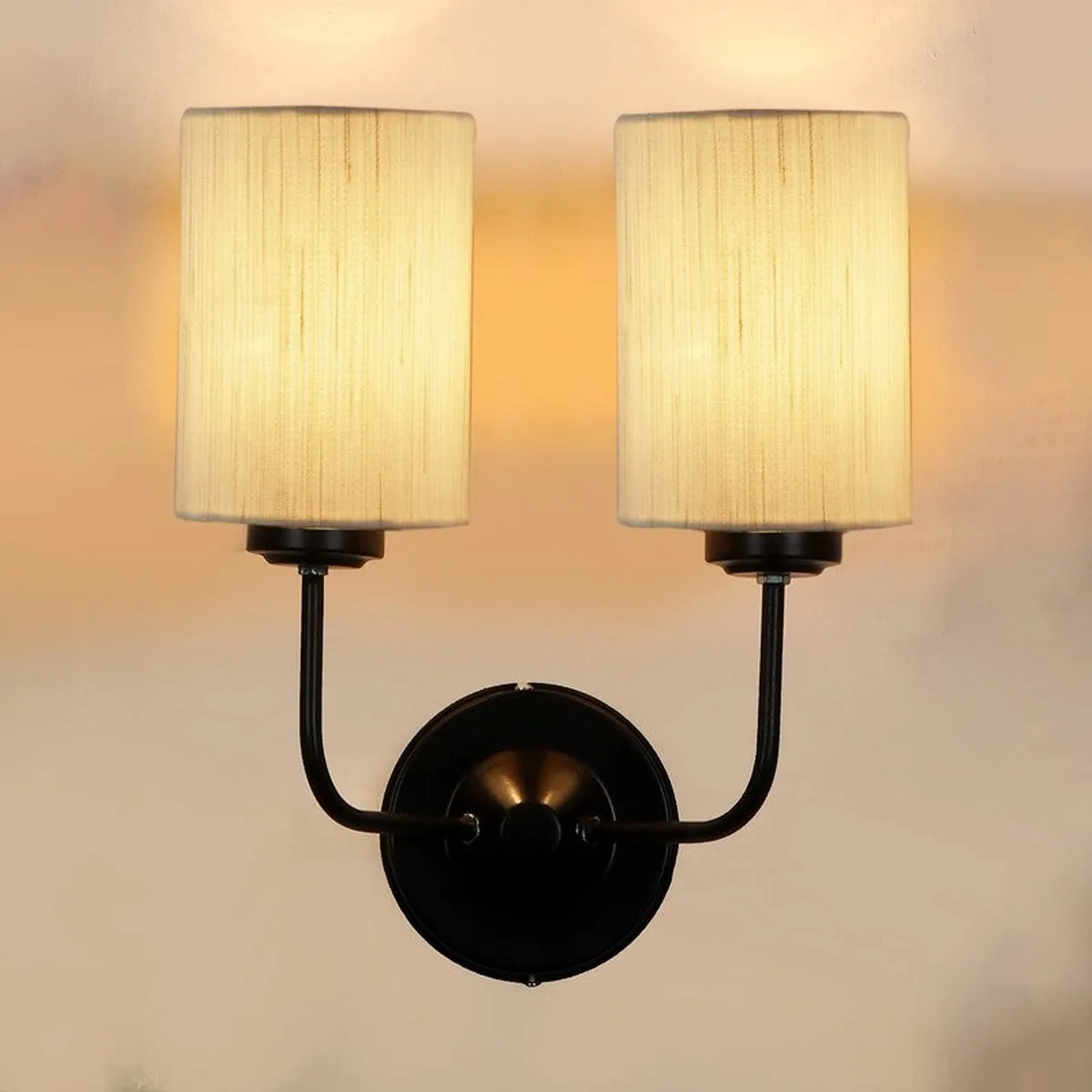 Front view of illuminated twin wall lamp with two white shades