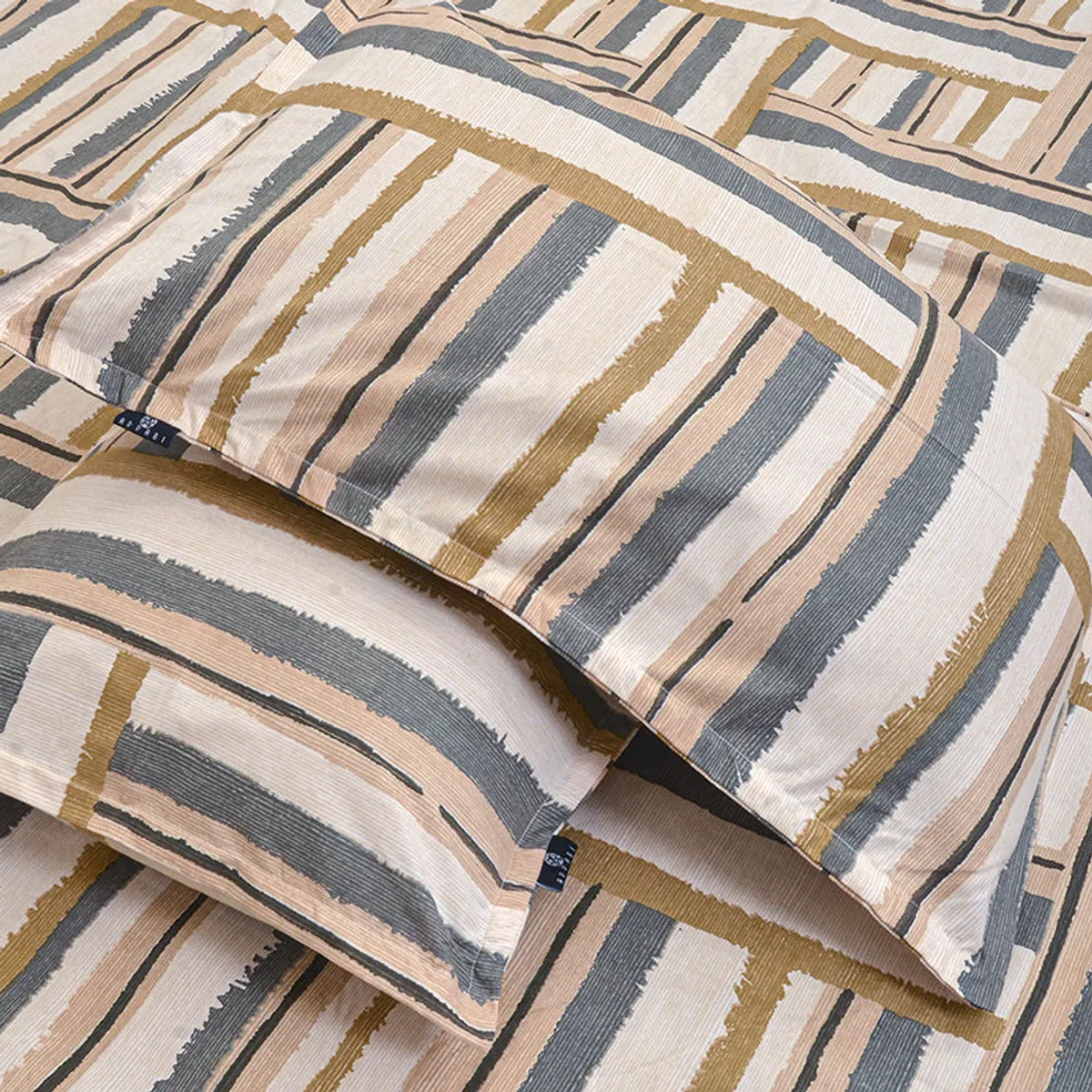 Detail of the bedsheet and pillow covers showing linear striped pattern