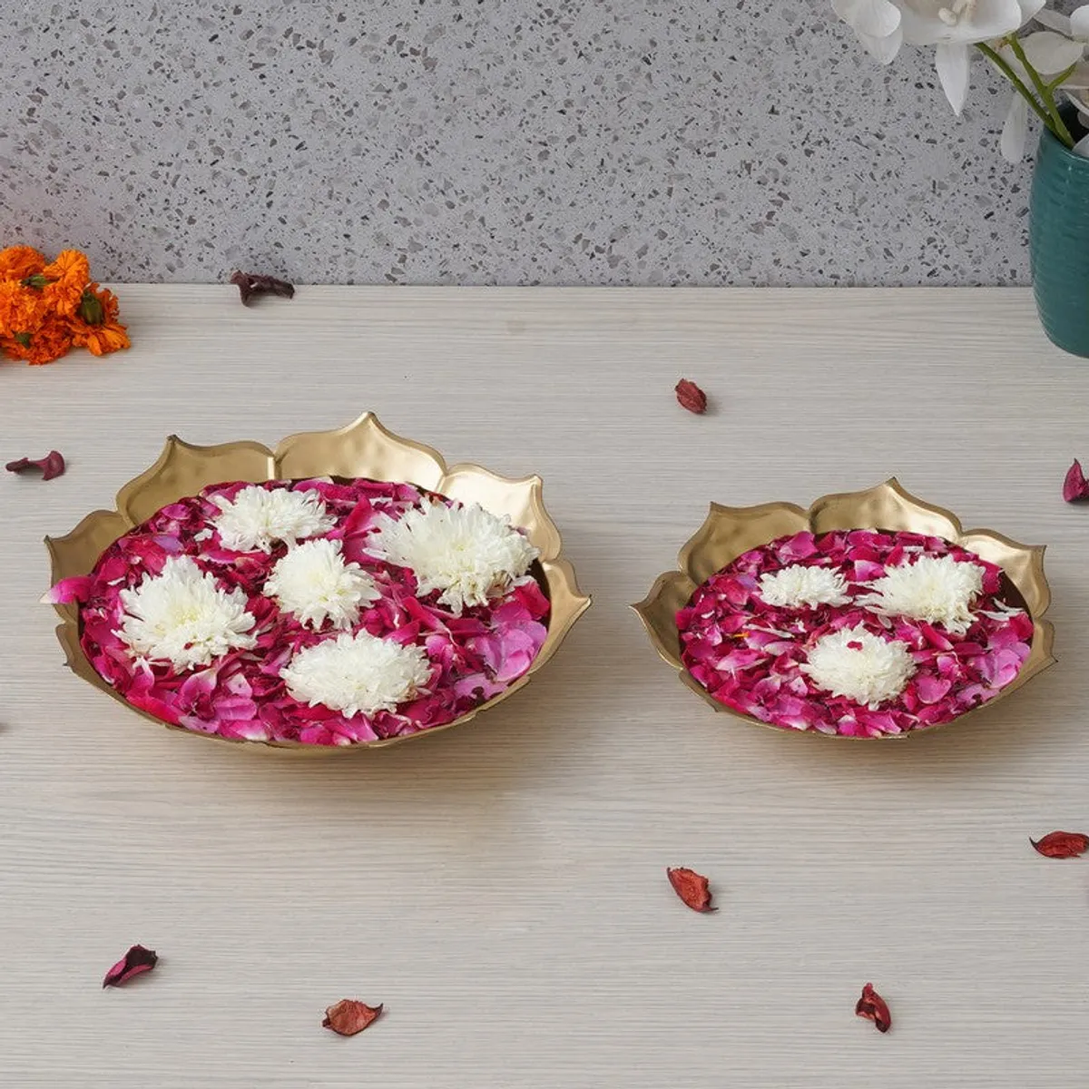 Two gold petal-edge urlis displayed on a light tabletop