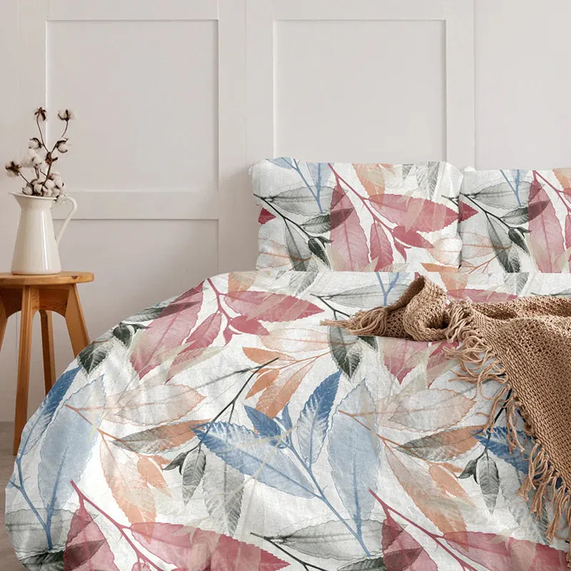 White duvet cover with pink, blue and grey botanical leaf print styled on a bed