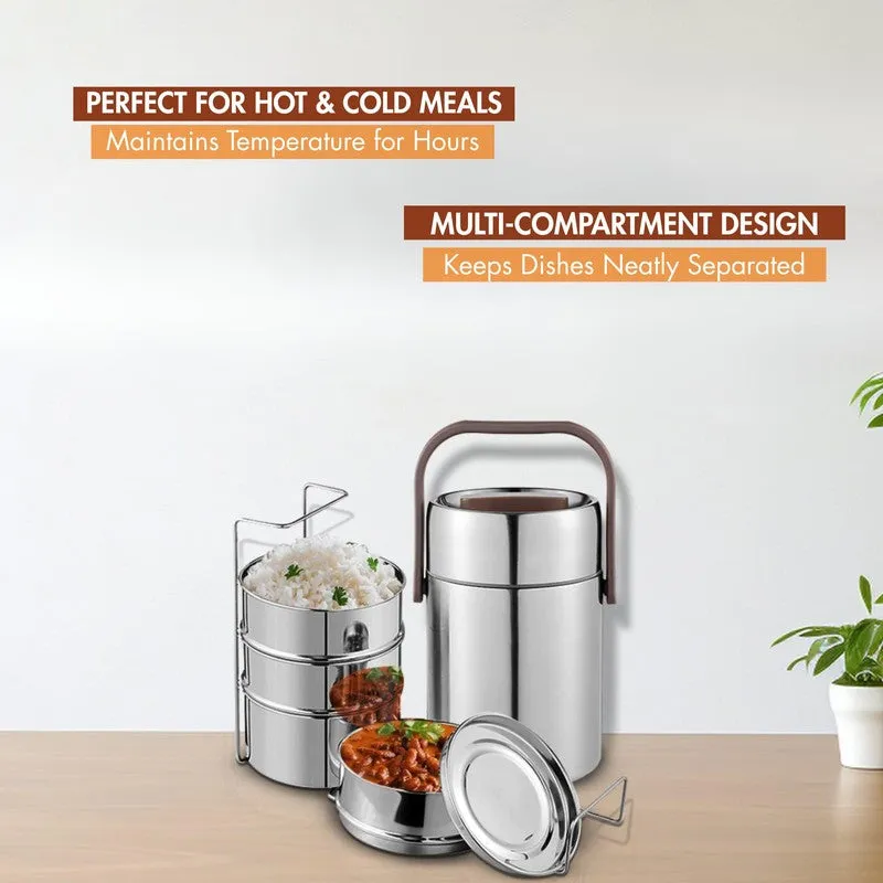 Silver tiffin carrier and three stacked containers displayed with rice and curries