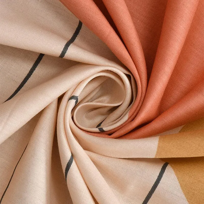 Close-up of beige, peach and yellow geometric cotton bedsheet fabric