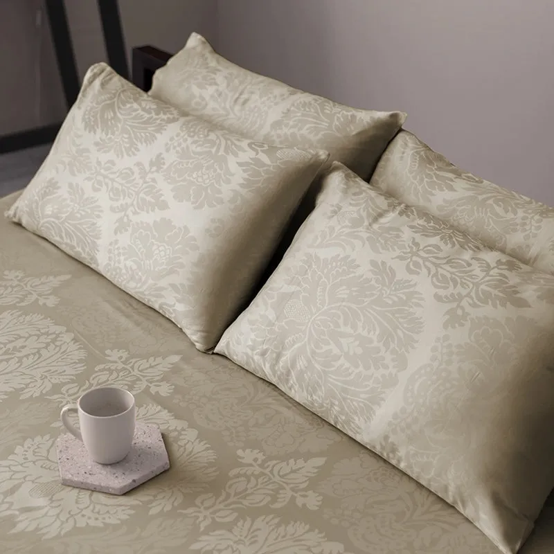 Matching beige floral pillow covers and bedsheet styled with a cup