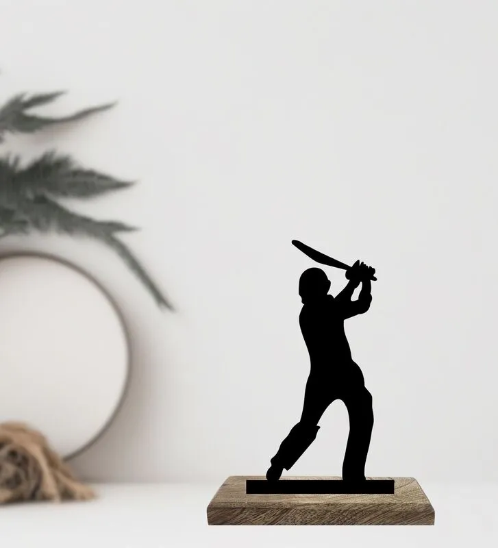 Black cricket batter figurine on a wooden base against a soft neutral backdrop