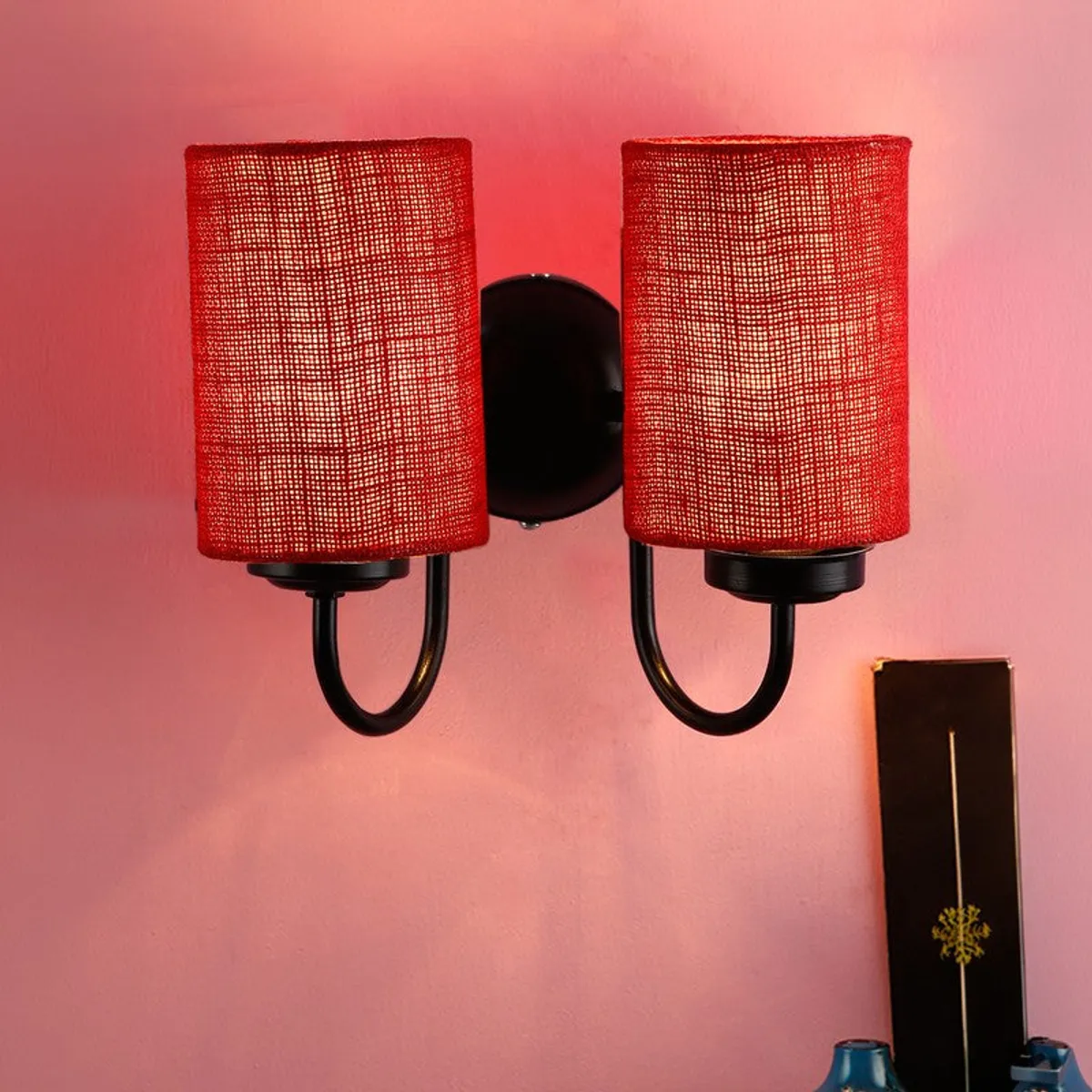 Front view of red dual jute wall lamp with black iron base