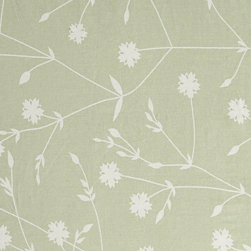 Detailed view of the white floral pattern on green bedding fabric