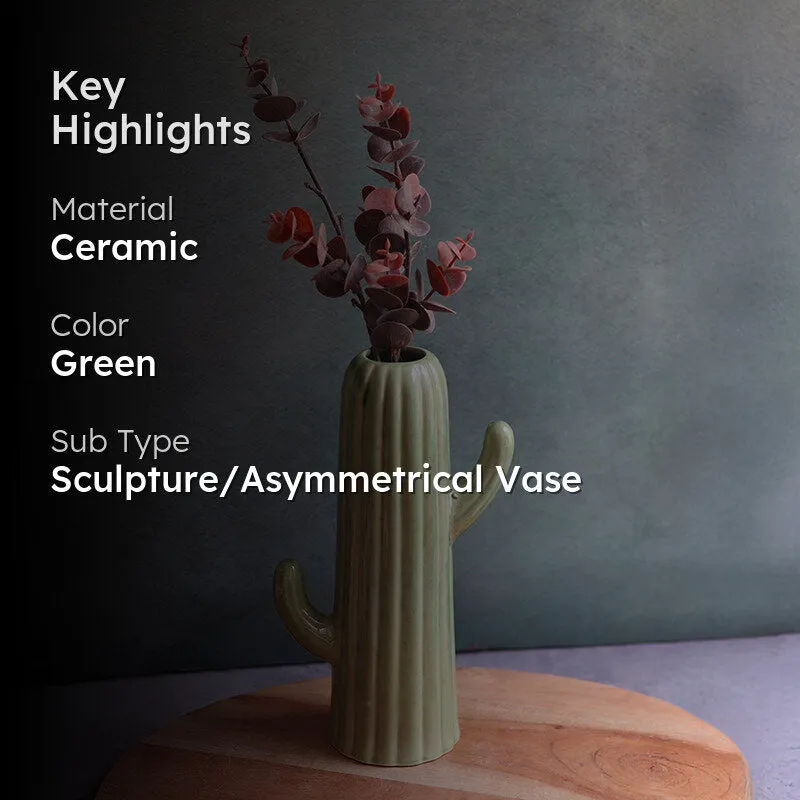 Dark green cactus-shaped vase with dried stems against a moody backdrop