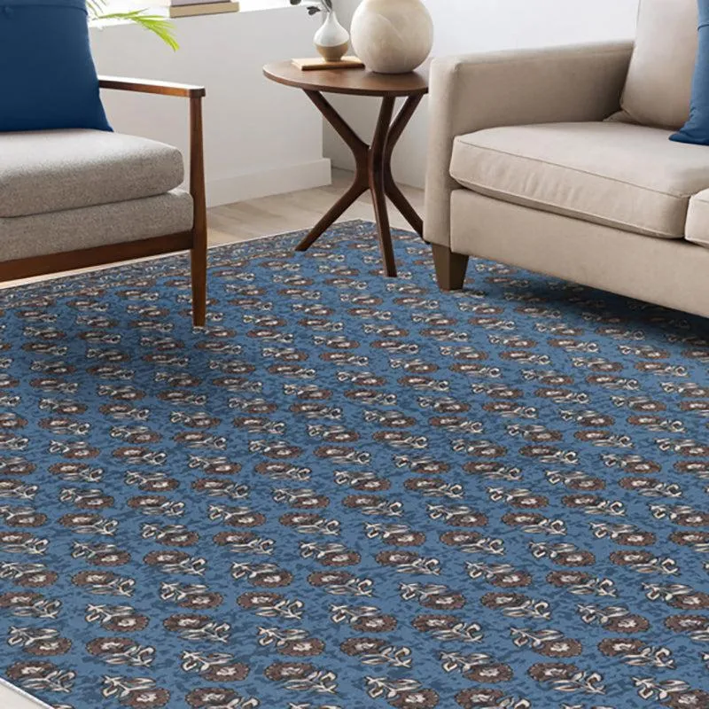 Blue rectangular carpet with repeating ethnic floral motifs in a living room