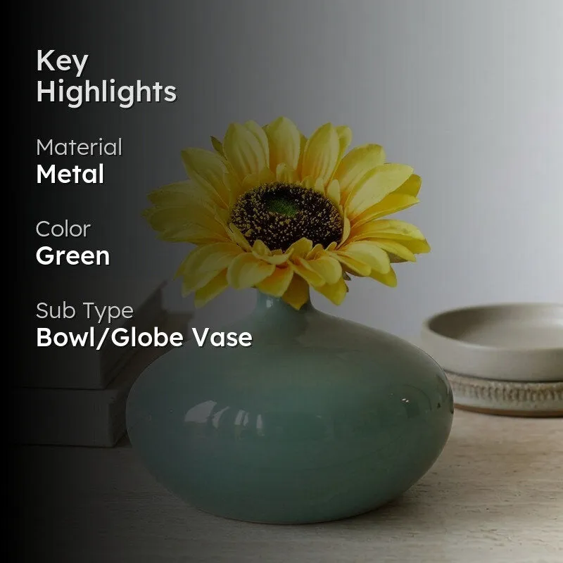 Green metal bowl or globe vase with yellow flower and highlights text