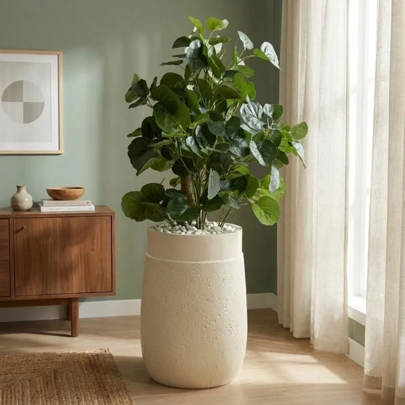 White floor planter holding a leafy plant in a bright living room