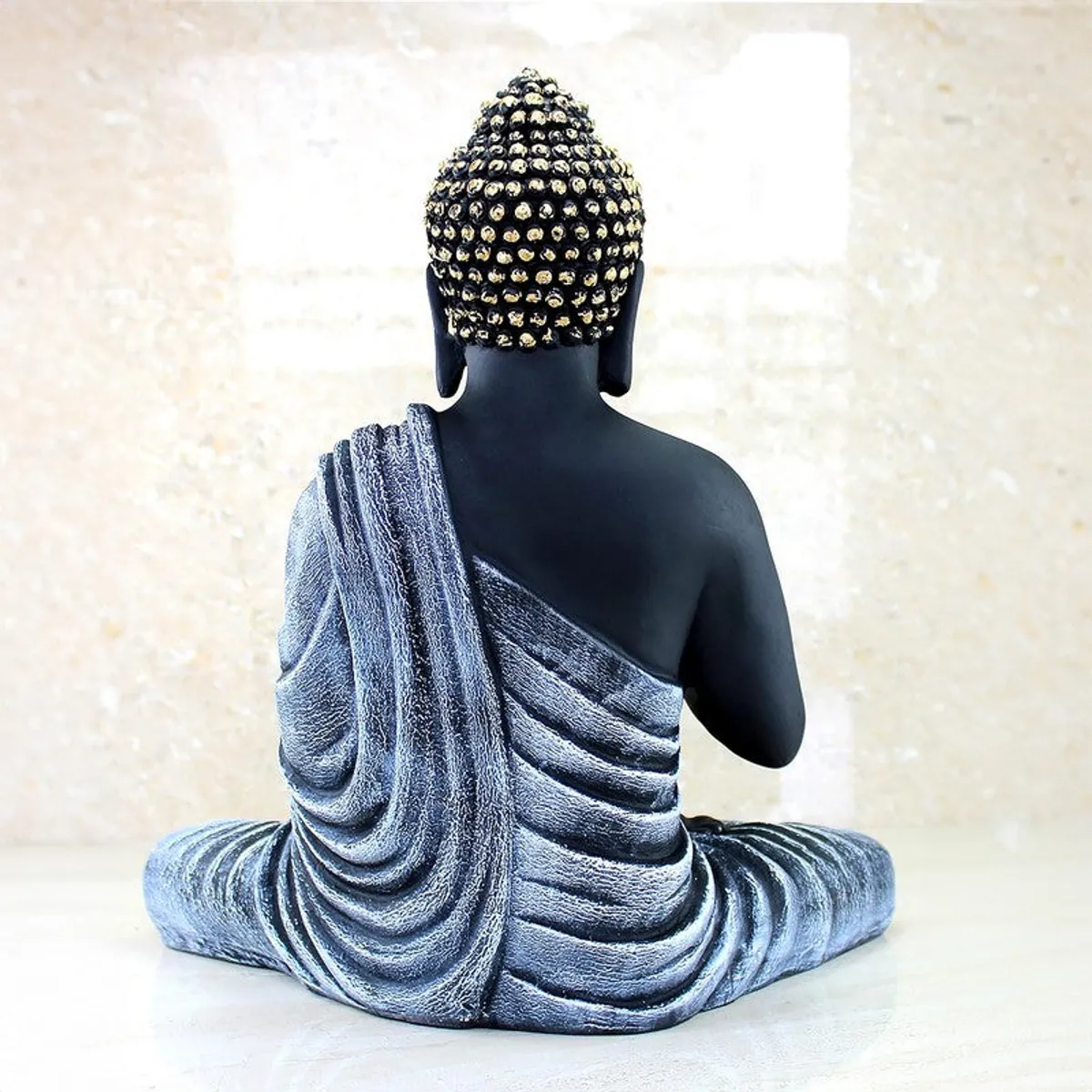 Rear view of Buddha idol showing draped robe detailing
