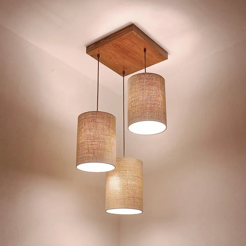 Lit cluster ceiling lamp with wooden mount and beige drum shades