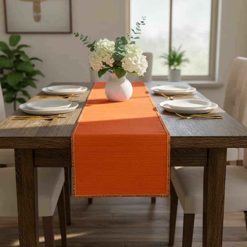 Orange table runner arranged on a dining table with four place settings