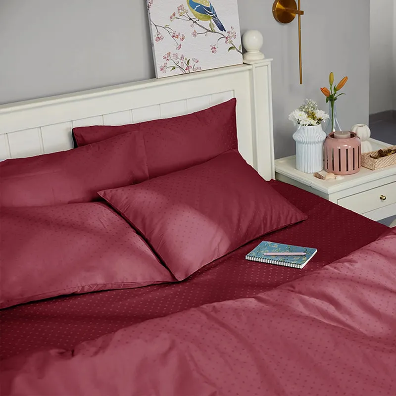 Maroon patterned duvet cover arranged in a bright bedroom