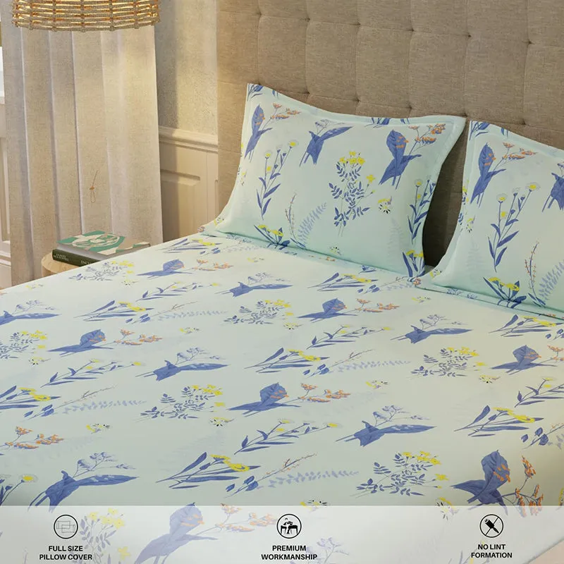 Close-up of mint blue bedsheet with blue bird and floral pattern and matching pillow covers