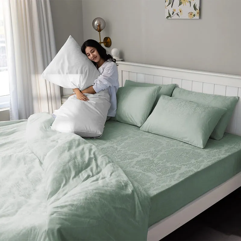 Sage green fitted bedsheet with matching pillow covers in a bedroom