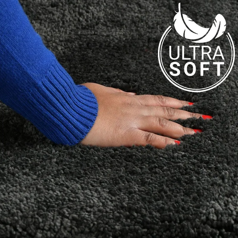 Close-up of plush dark grey bath mat texture under a hand