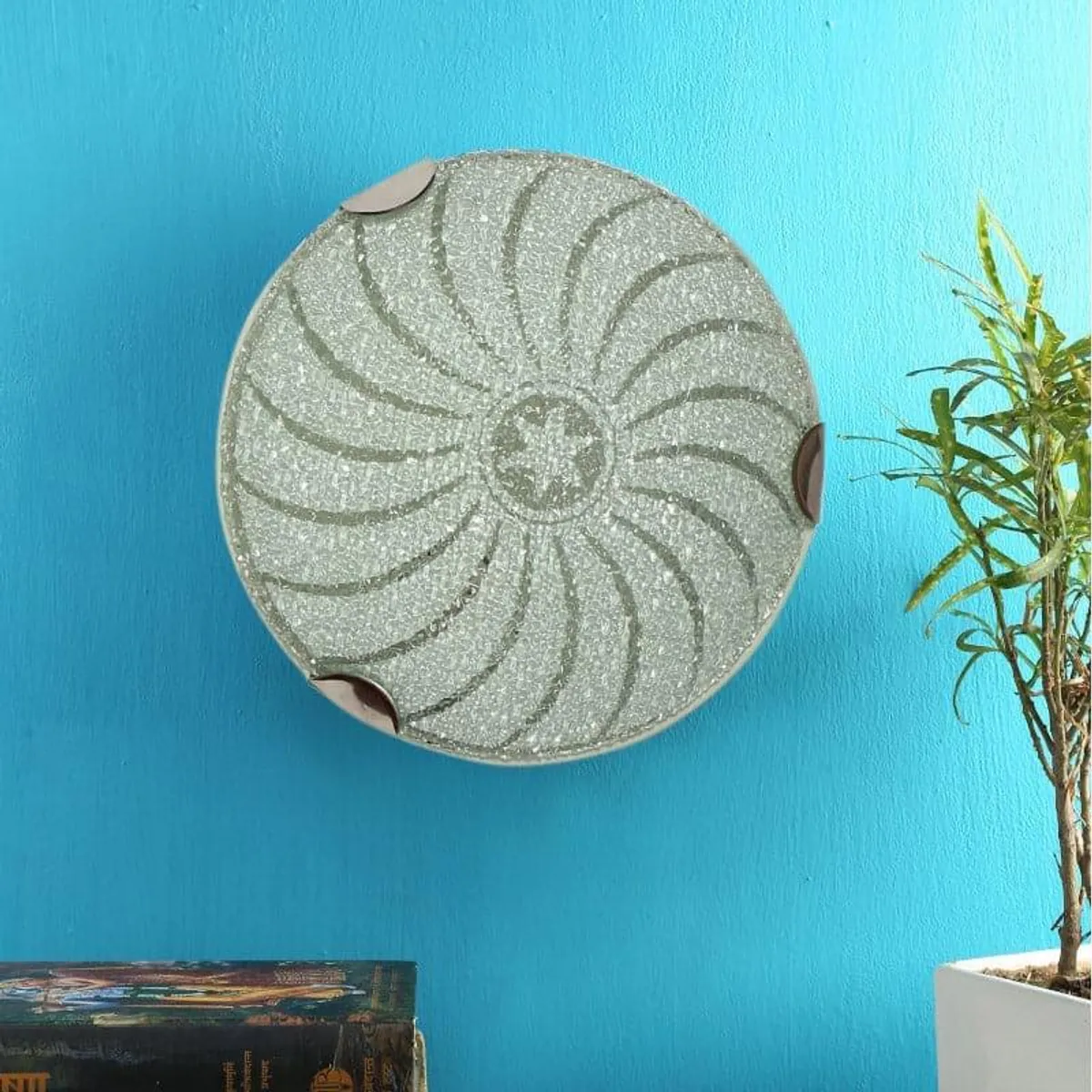 Round frosted glass wall lamp with swirl pattern mounted on a blue wall