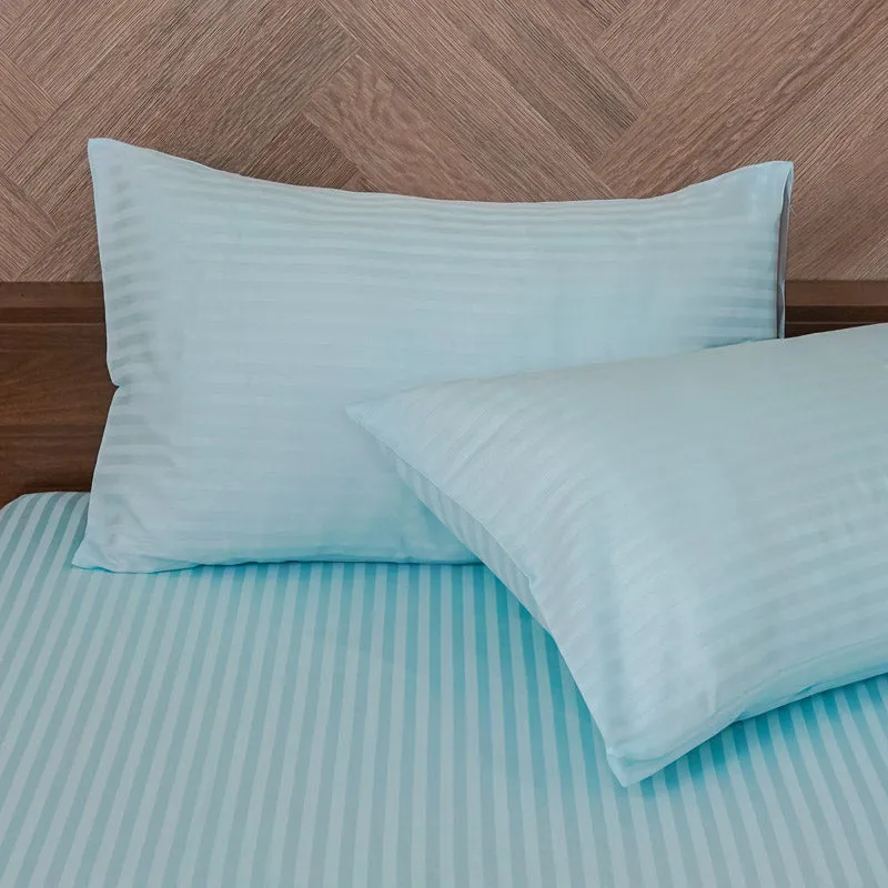 Close-up of matching light blue striped pillow covers on the bedsheet