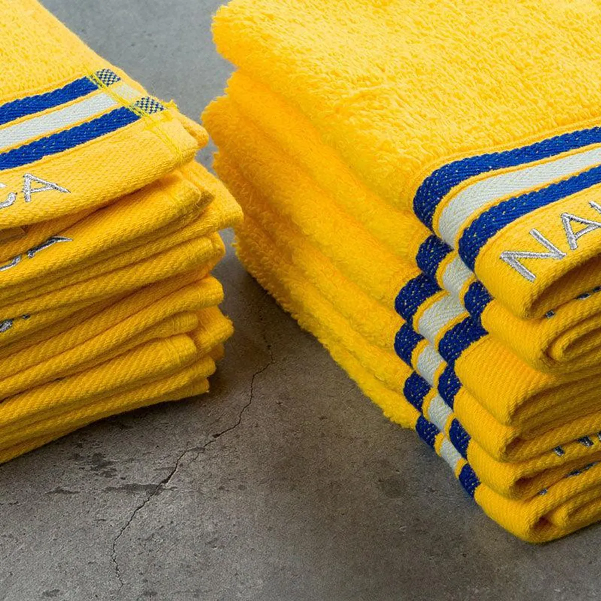 Close-up view of plush yellow towels with contrasting striped borders
