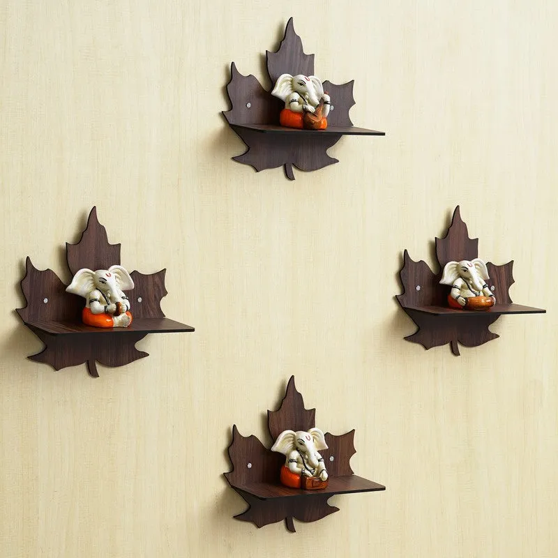 Angled view of four brown leaf-shaped wall accents with Ganesha figures