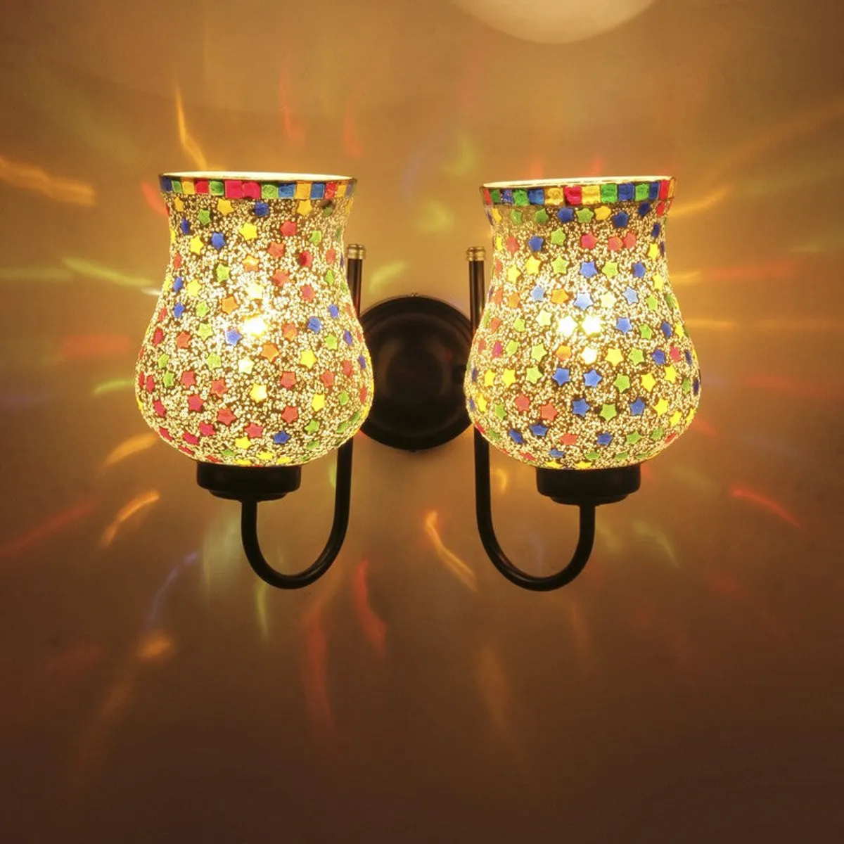 Front view of lit twin glass wall lamp casting colourful light patterns