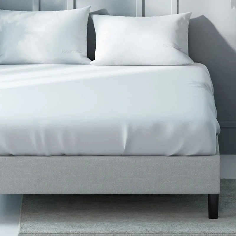 Close-up of a white bedsheet draped over a modern bed